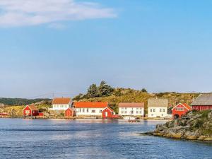 KorshamnにあるTwo-Bedroom Holiday home in Lyngdal 1の水上に白と赤の家屋が建つ町