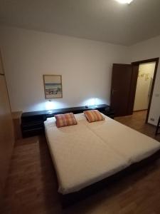 een slaapkamer met een groot wit bed met 2 kussens bij IL VICOLO_Carinissimo appartamento in centro storico, zona giorno mansardata in Belluno