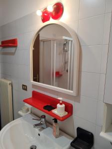 La salle de bains est pourvue d'un lavabo et d'un miroir. dans l'établissement IL VICOLO_Carinissimo appartamento in centro storico, zona giorno mansardata, à Belluno