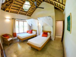 a bedroom with two beds and a window at The Makokola Retreat in Mponda