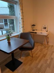 ヴィボーにあるMotel Viborgのデスク、テーブル、椅子が備わるオフィス