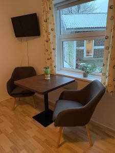 ein Esszimmer mit einem Tisch, 2 Stühlen und einem Fenster in der Unterkunft Motel Viborg in Viborg