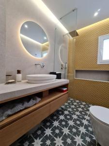 een badkamer met een wastafel, een spiegel en een toilet bij Simple & Noble in Athene