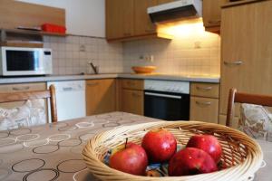 a basket of apples sitting on a table in a kitchen at Appartementhaus Kraker in Presseggersee