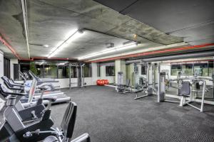 einen Fitnessraum mit vielen Kardiogeräten in einem Gebäude in der Unterkunft Naima Hotel in Melbourne