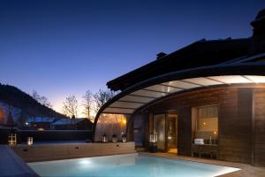 une maison avec une piscine et un bâtiment dans l'établissement Hôtel et Spa Le Vermont, au Grand-Bornand