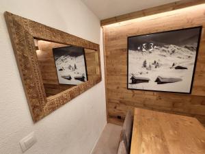 a dining room with a wooden table and a picture on the wall at 40m2 - Ski aux pieds - La Tania - Parking couvert in La Tania