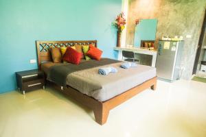 1 dormitorio con 1 cama grande y almohadas coloridas en K-Bunk AoNang Center, en Ao Nang Beach