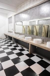 a bathroom with sinks and mirrors on a checkered floor at K-Bunk AoNang Center in Ao Nang Beach