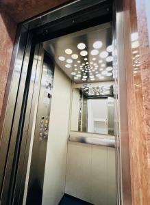 an elevator in an office building with a mirror at FELLINI SUITES Lungomare near the sea in Catania +29 photos