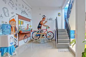 a hallway with a mural of a man on a bike at OYO 91952 Oase Hostel in Yogyakarta