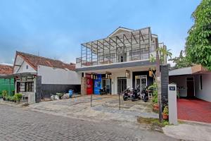 um edifício com uma moto estacionada em frente em OYO 91952 Oase Hostel em Yogyakarta