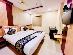 HOTEL SM DECCAN PARK في شامشاباد: غرفه فندقيه سرير وتلفزيون
