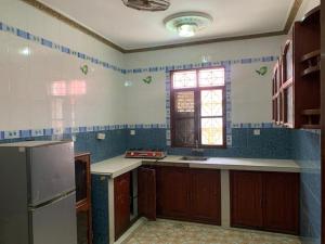 a kitchen with wooden cabinets and a window in it at Sawa Sawa Apartment in Ngambo