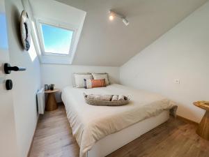 een slaapkamer met een groot bed en een raam bij Stijlvol appartement aan het strand van Oostduinkerke in Oostduinkerke