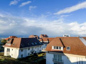 a group of houses with roofs and a sky at Stijlvol appartement aan het strand van Oostduinkerke in Oostduinkerke
