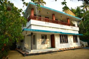 a white house with a blue roof at Dhakshina Homestay in Cochin