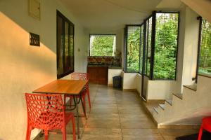 a dining room with a table and chairs and windows at Dhakshina Homestay in Cochin