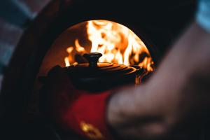 un horno de fuego con un jarrón delante de él en untether on Olive View en Wellington