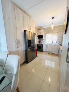 a small kitchen with a stainless steel refrigerator at The Escape Haven in Sandton