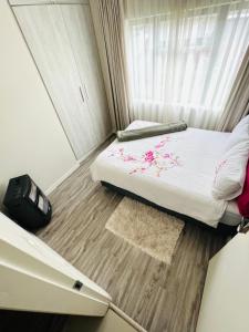 a small bedroom with a bed with flowers on it at The Escape Haven in Sandton
