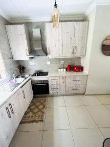 a kitchen with white cabinets and a sink at The Escape Haven in Sandton
