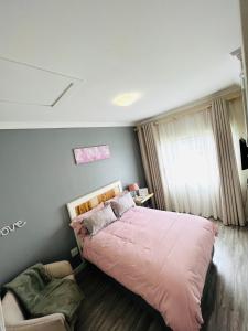 a bedroom with a large bed and a chair at The Escape Haven in Sandton