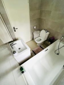 a white bathroom with a toilet and a sink at The Escape Haven in Sandton