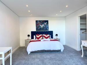 a bedroom with a bed and a painting on the wall at Private Pool! Bantry Bay Large Flat with Solar in Cape Town
