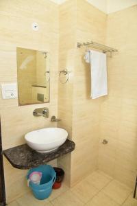 La salle de bains est pourvue d'un lavabo et d'un miroir. dans l'établissement THE TRINETRA VILLA, à Sawai Madhopur