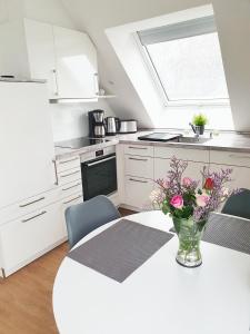 a kitchen with a vase of flowers on a table at Ferienwohnung Beste - für eine entspannte Auszeit in Bad Oldesloe