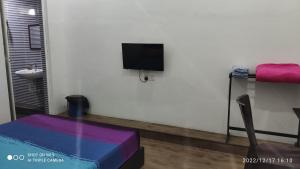 um quarto com uma cama e uma televisão na parede em BENUTHOMESTAY em Johor Bahru