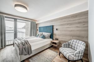 レンゲンフェルトにあるNativo Bergapartsのベッドルーム1室(ベッド1台、椅子、窓付)