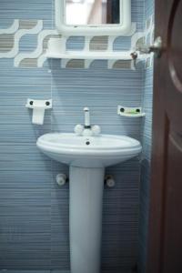 a bathroom with a white sink and a mirror at GOHO Rooms Badar in Karachi