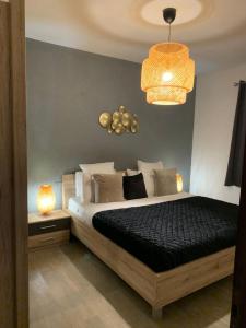 1 dormitorio con cama y lámpara de araña en La Maison de la Mer, en Posada