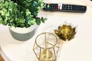 a white counter with a plant and a gold candleholder at City-Apartment in Krefeld - BEUYS Apartments - Krefeld in Krefeld +7 photos
