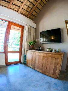 sala de estar con TV de pantalla plana en la pared en The Makokola Retreat, en Mangochi