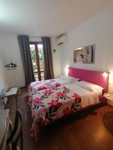 a bedroom with a large bed with a pink headboard at SelfMatic in Orio al Serio