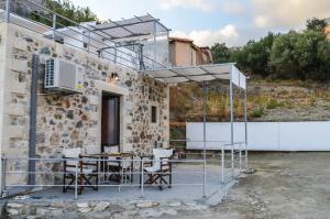 a patio with a table and chairs next to a building at Villa Irena 2 bedrooms in Agalianós