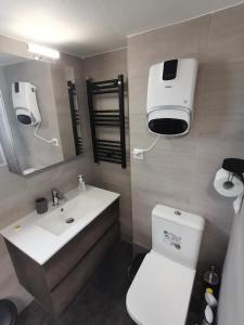 uma casa de banho com um WC branco e um lavatório. em Penthouse spacious w super wifi & terrace, 2 min from metro em Atenas