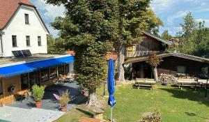 a building with a blue umbrella in a yard at Hotel Weißbräu in Oberhaching