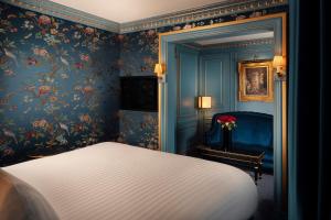 a bedroom with a bed and floral wallpaper at Maison Proust, Hotel & Spa La Mer in Paris
