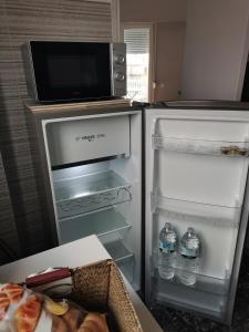 um frigorífico aberto com um micro-ondas em cima em Penthouse spacious w super wifi & terrace, 2 min from metro em Atenas