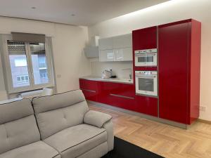 un soggiorno con divano e una cucina rossa di Suite San Paolo Tv Cinema a Roma