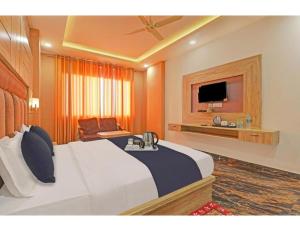 a hotel room with a large bed and a television at Hotel Paras Inn, Lucknow in Lucknow