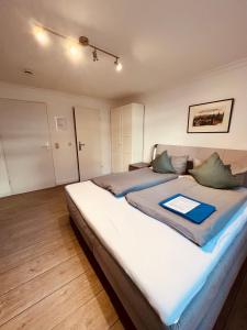 a bedroom with two beds with a blue folder on them at Ostseehaus Dreesen Souterrain in Timmendorfer Strand