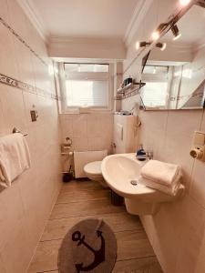 ティメンドルファー・シュトラントにあるOstseehaus Dreesen Souterrainのバスルーム(洗面台、トイレ、鏡付)