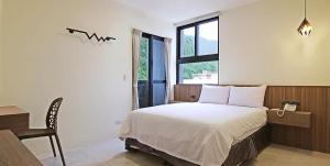 una camera da letto con un letto, un tavolo e una finestra di Smile Ocean Homestay a Green Island