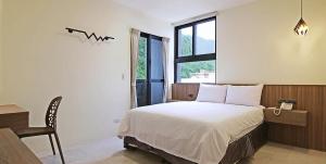 a bedroom with a bed and a table and a window at Smile Ocean Homestay in Green Island