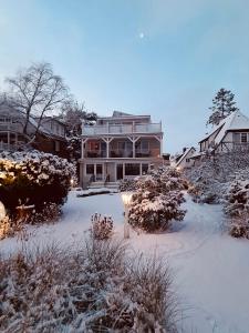 a large house with a light in the snow at Ostseehaus Dreesen Souterrain in Timmendorfer Strand